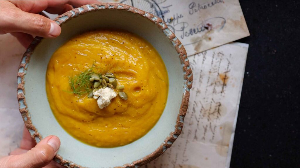 hero image of finished butternut squash soup with fennel fronds and pumpkin seeds and ricotta